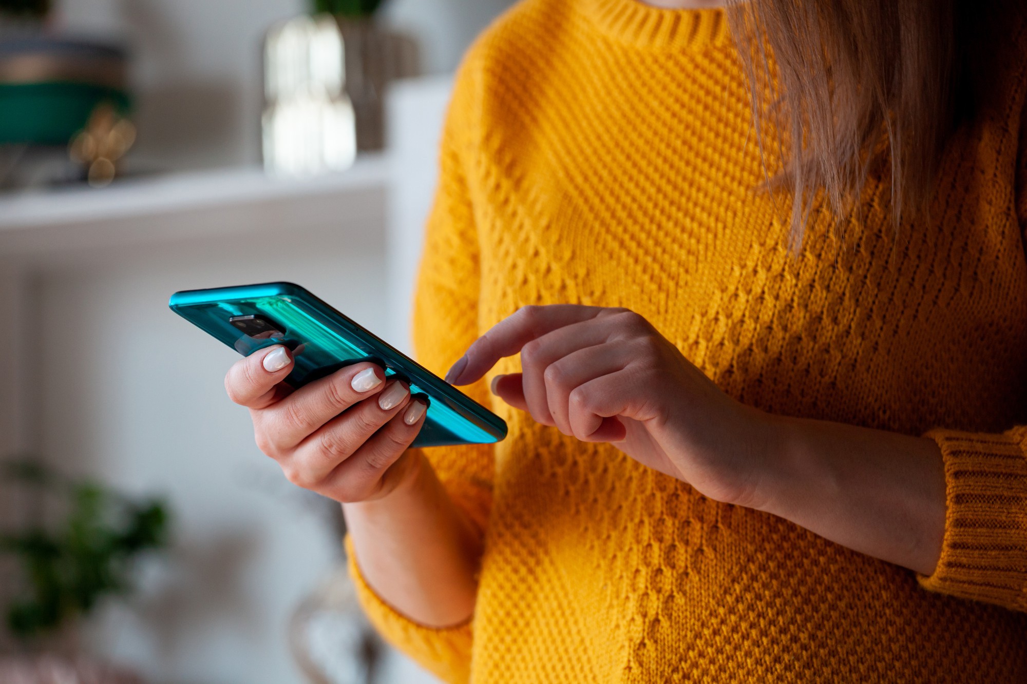 Frau bedient eine App auf dem Smartphone zu Hause